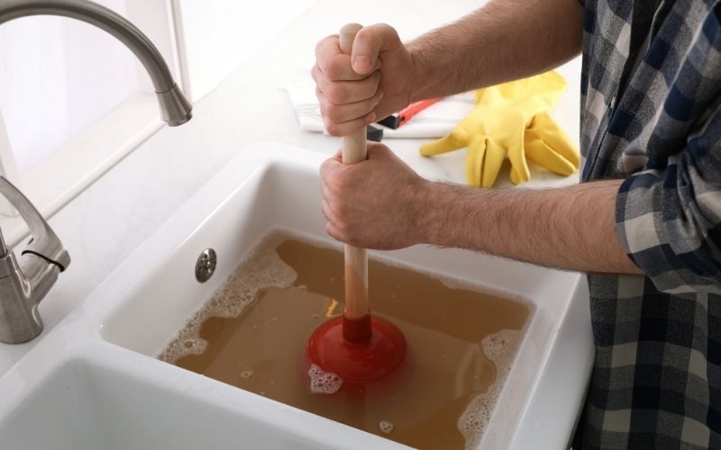 Plombier effectuant un débouchage de canalisation à Grasse avec furet et hydrocurage